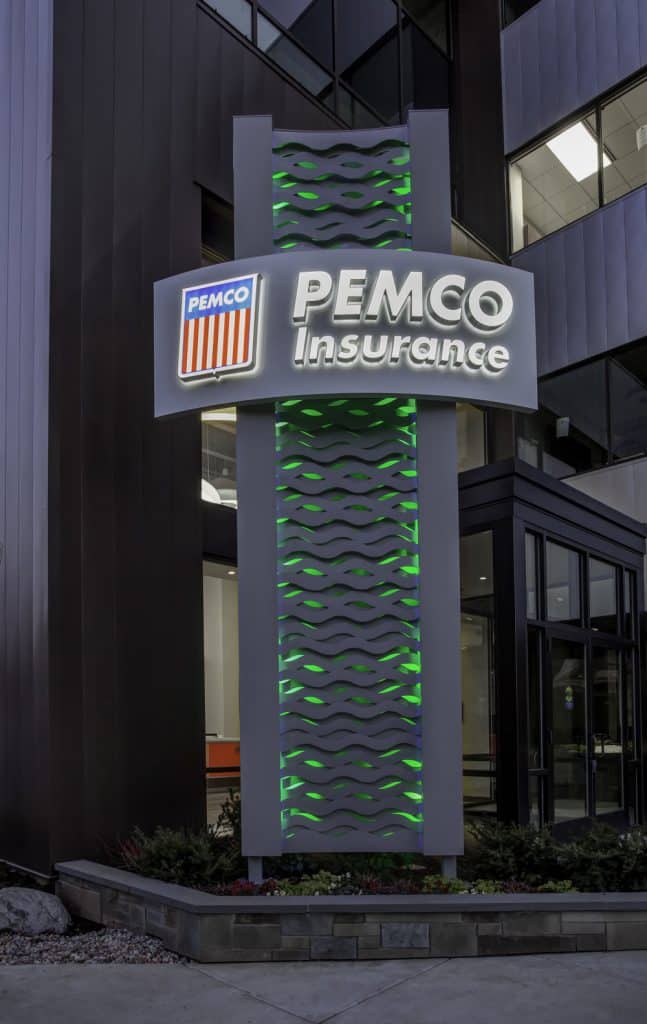 Signage for PEMCO Insurance with illuminated green accents in front of a modern building. Signage for PEMCO Insurance with illuminated green accents in front of a modern building.
