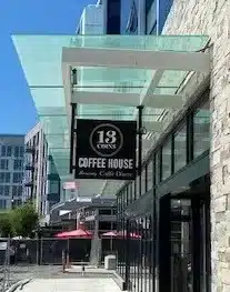 Exterior of a building with a sign reading "13 Coins Coffee House, Bakery, Café, Desserts" under a glass awning. Exterior of a building with a sign reading "13 Coins Coffee House, Bakery, Café, Desserts" under a glass awning.
