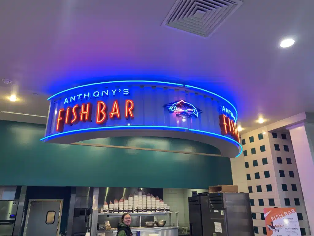 Anthony's Fish Bar neon sign with blue lights and a fish logo inside a restaurant. Anthony's Fish Bar neon sign with blue lights and a fish logo inside a restaurant.