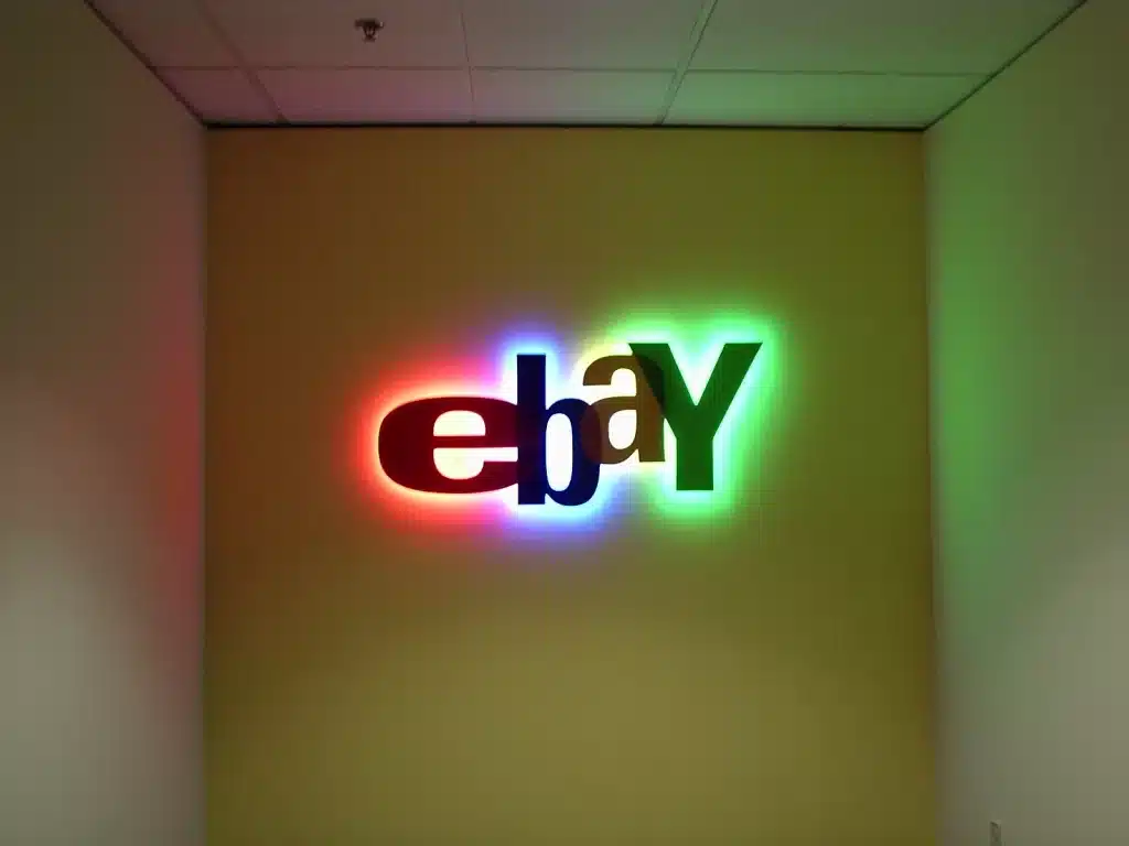 OLYMPUS DIGITAL CAMERA Illuminated eBay logo on a wall, displaying vibrant colors: red, blue, green, and yellow.