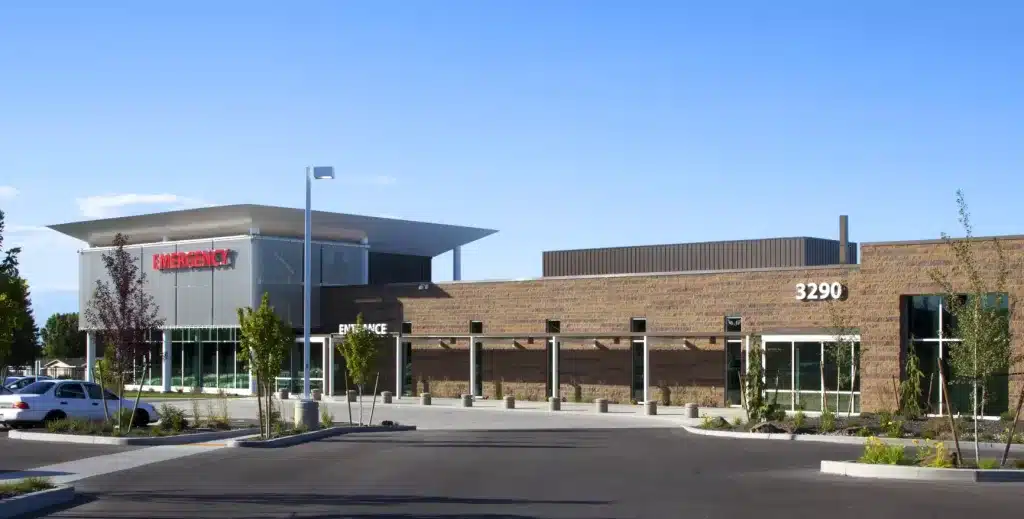 Modern emergency facility with a flat-roof design, clear blue sky, and surrounding trees. Building number 3290 is visible on the front. Modern emergency facility with a flat-roof design, clear blue sky, and surrounding trees. Building number 3290 is visible on the front.